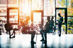 Background concept with business people silhouette working in the office near a window glass. Double exposure and light effects photo