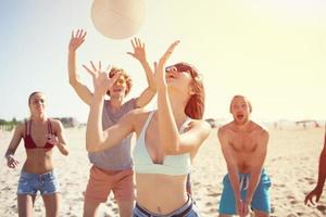 Group of friends playing at beach volley at the beach photo