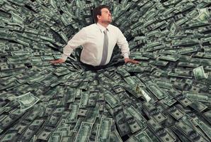 Businessman swallowed by a black hole of money. Concept of failure and economic crisis photo