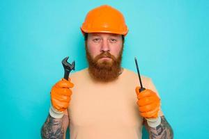 trabajador con amarillo sombrero es confuso acerca de su trabajo foto