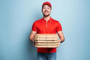 Happy deliveryman happy to delivers pizza with success. Cyan background photo