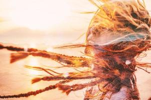 Woman with hair blowing in the wind during sunset photo