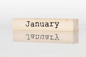 a wooden cube with the inscription January on a white background photo