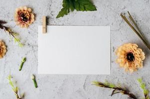 White paper and beautiful flowers on marble background photo