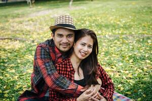 romántico joven Pareja sentado en jardín foto