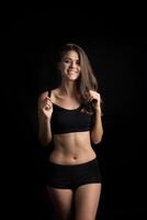 Beautiful woman with healthy body on black background photo