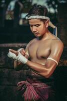 el boxeador se sentó en la piedra, ató la cinta alrededor de su mano, preparándose para pelear. foto