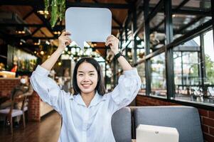 photo a young woman in a white shirt holding a thought box symbol