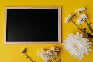 chalkboard on yellow background decorated with flowers photo