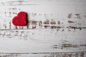 photo red yarn heart shaped on the wall background