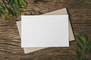 blank piece of paper with an envelope on  wooden background photo