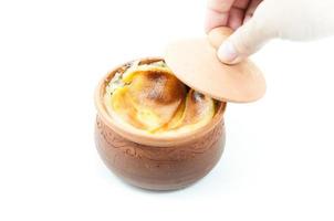 Thai dessert in clay pots in woman hand,Mung Bean Thai Custard Dessert on white background,thai food style photo