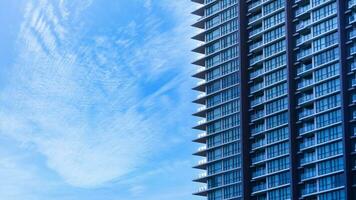 Glass building with balcony with blue sky background,Abstract part of modern architecture, glass and concrete walls photo