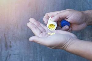 Doctor's pouring yellow tablets in the palm for a patient. photo