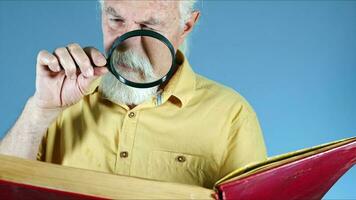 antiguo hombre mirando a libro con aumentador vaso foto