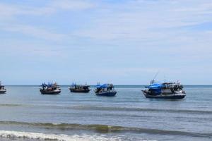 Wooden fishing boat in the blue sea, going to the ocean for fish. photo