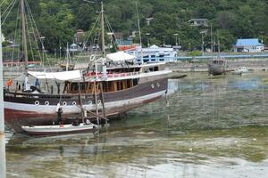 Indonesian traditional Phinisi ship. Pinisi or phinisi is a traditional two-masted Indonesian sailing ship. These boats are made to sail the waters of the Indonesian archipelago photo