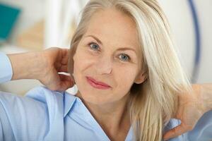 Modern businesswoman. Beautiful middle aged woman looking at camera with smile while siting in the office. photo