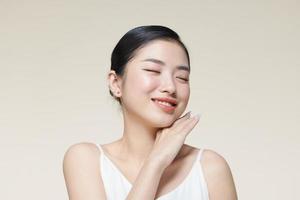 Smiling asian woman touching healthy skin portrait photo