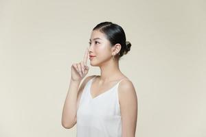 Young woman touching her nose with her finger photo