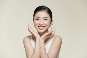 Smiling asian woman touching healthy skin portrait photo