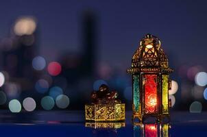 linterna y plato pequeño de dátiles con cielo nocturno y fondo claro de la ciudad para la fiesta musulmana del mes sagrado del ramadán kareem. foto