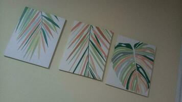 canvas painting depicting palm leaves on a white wall photo