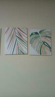 canvas painting depicting palm leaves on a white wall photo