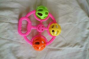 a colorful toddler toy that can make a tinkling sound with a pink handle photo