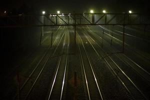 Railroad at night. Rails at station. Many tracks for trains. photo