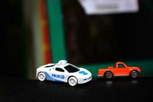 concepto foto de un juguete policía coche persiguiendo un naranja coche