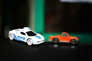concepto foto de un juguete policía coche persiguiendo un naranja coche