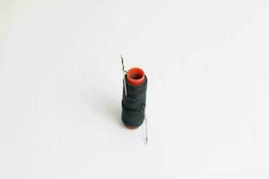 Spool of black sewing thread on a white background photo