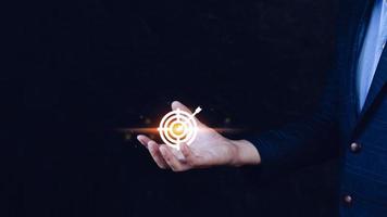 Targeting concept with businessman hand holding digital image of dartboard,Businessman holding virtual dartboard and arrow with copy space for setup business objective target concept. photo