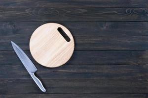 cuchillo de cocina y tabla de cortar vacía redonda de madera foto