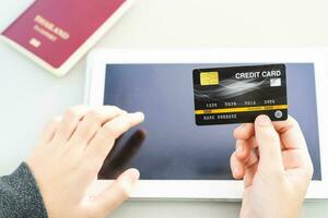 Close up of women hand holding credit card with tablet computer blank space screen photo