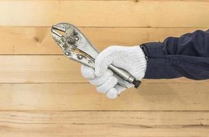 Hand in glove holding Adjustable wrench photo