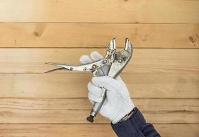 Hand in glove holding Adjustable wrench photo