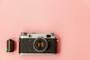 Clásico película foto cámara lente y película rodar en rosado pastel de moda antecedentes