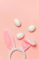 Decorative white eggs and bunny ears furry costume toy isolated on trendy pastel pink background photo