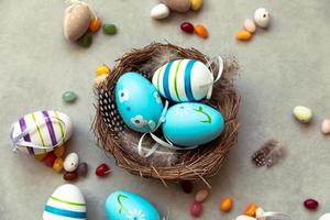 Happy Easter concept. Preparation for holiday. Colorful decorated blue easter eggs in nest on concrete stone grey background. Simple minimalism flat lay top view. Postcard background banner on Easter. photo