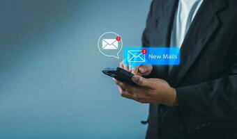 Businessman using smartphone with new email alert. Communication connection messages in global workplaces through email marketing or digital newsletter photo