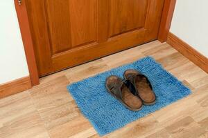 blue door mat and footwear with close door photo