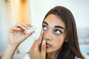 mujer utilizando ojo gota. hembra goteante ojo lubricante a tratar seco ojo o alergia. enfermo niña tratando globo ocular irritación o inflamación, enfermo mujer sufrimiento desde irritado ojo, óptico síntomas. foto