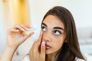 Woman using eye drop, woman dropping eye lubricant to treat dry eye or allergy sick girl treating eyeball irritation or inflammation  sick woman suffering from irritated eye, optical symptoms photo