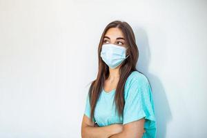 Girl in respiratory mask. Masked woman looks at camera. Cold, flu, virus, tonsillitis, respiratory disease, quarantine, epidemic concept. Beautiful caucasian young woman with disposable face mask photo