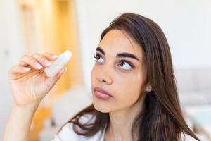 Woman using eye drop. Female dropping eye lubricant to treat dry eye or allergy. Sick girl treating eyeball irritation or inflammation sick woman suffering from irritated eye, optical symptoms. photo