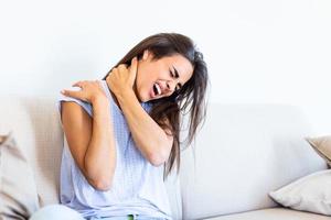 sensación exhausto. frustrado joven mujer mirando agotado, en dolor y masajear su cuello foto