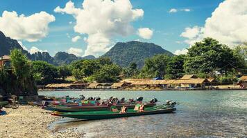 long tail boats on sunset at Song river, Vang Vieng, Laos. photo
