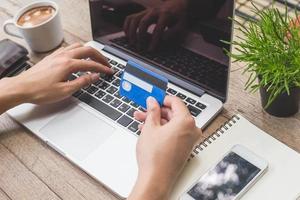 Man holding credit card and using laptop. Online shopping photo